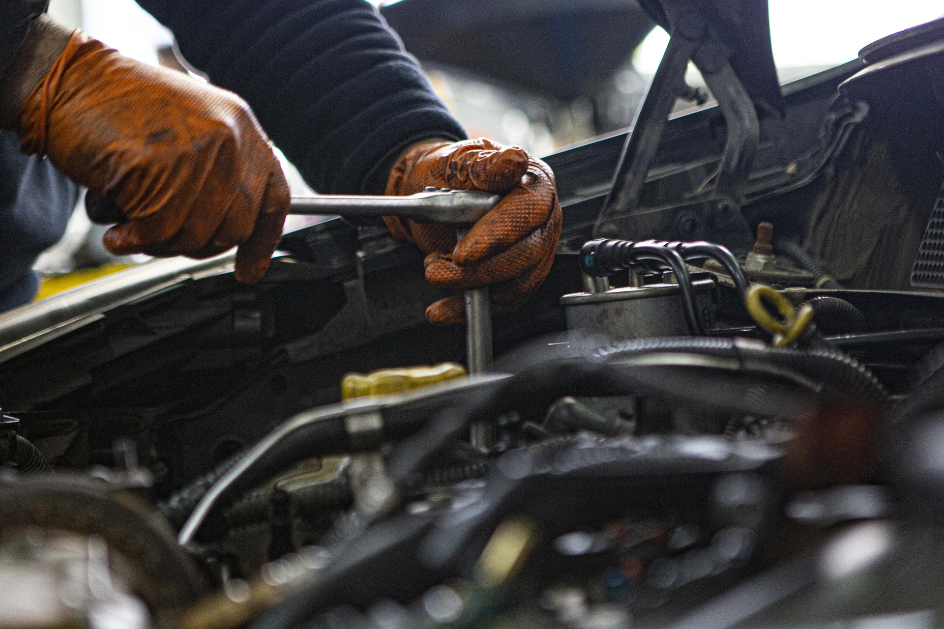 Working with a hand tool on a car engine at MAKROSTERGIOS – SOFRONAS