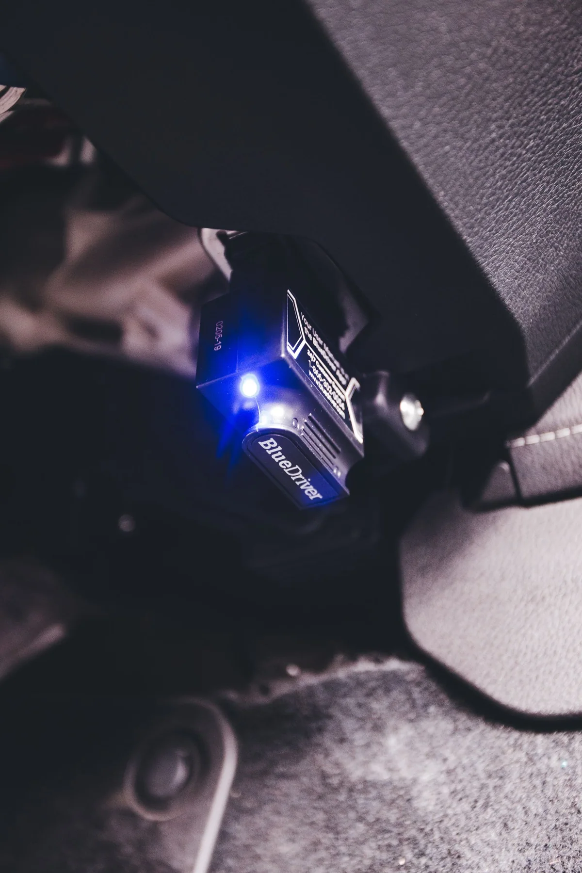 Diagnostic adapter connected to the car’s OBD port — illustrative service photograph