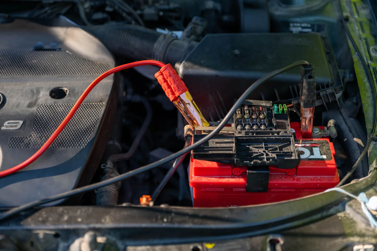 Test leads connected to a car battery — illustrative service photograph